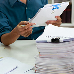 Hands prepping documents for scanning