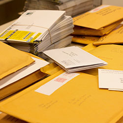 stacks of mail ballots and yellow envelopes